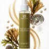 Brume capillaire sans rinçage Kératine & Algues Luxe sur fond minimaliste, entourée d'algues et de perles brillantes.